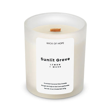 The Wick of Hope Sunlit Grove Candle features a white frosted glass, coconut soy wax, wooden wick, and minimalist label. Enjoy its refreshing lemon + musk scent. Non-toxic. Net Wt. 8 oz.