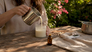 Candle maker pouring coconut soy wax into jar