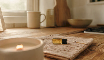 Wooden wick candle burning softly on wood table