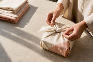 Hands tying fabric around a reusable gift