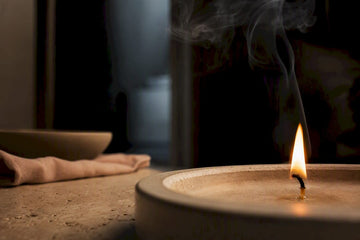 Candle flame with faint airborne smoke