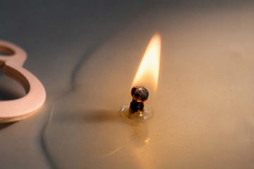 Mushrooming candle wick above melted wax