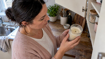 Woman inspecting an old jar candle