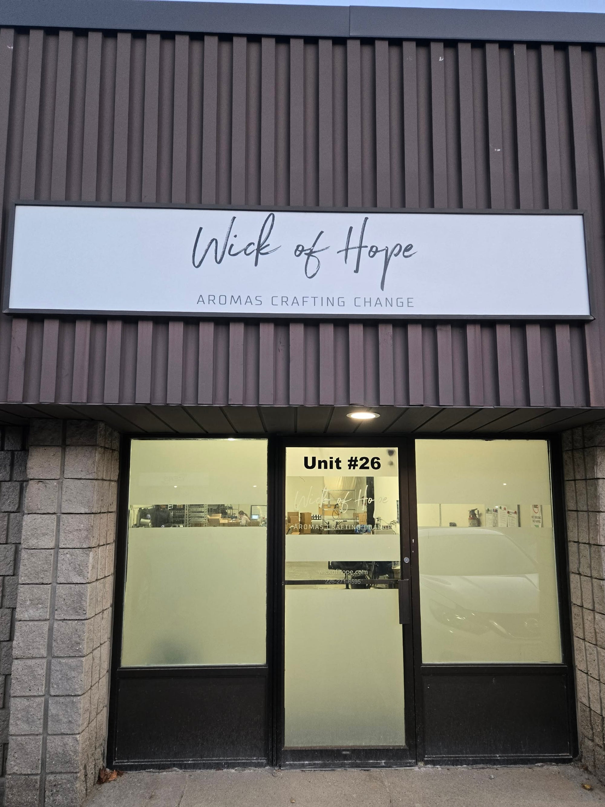 Storefront with 'Wick of Hope' sign above glass doors