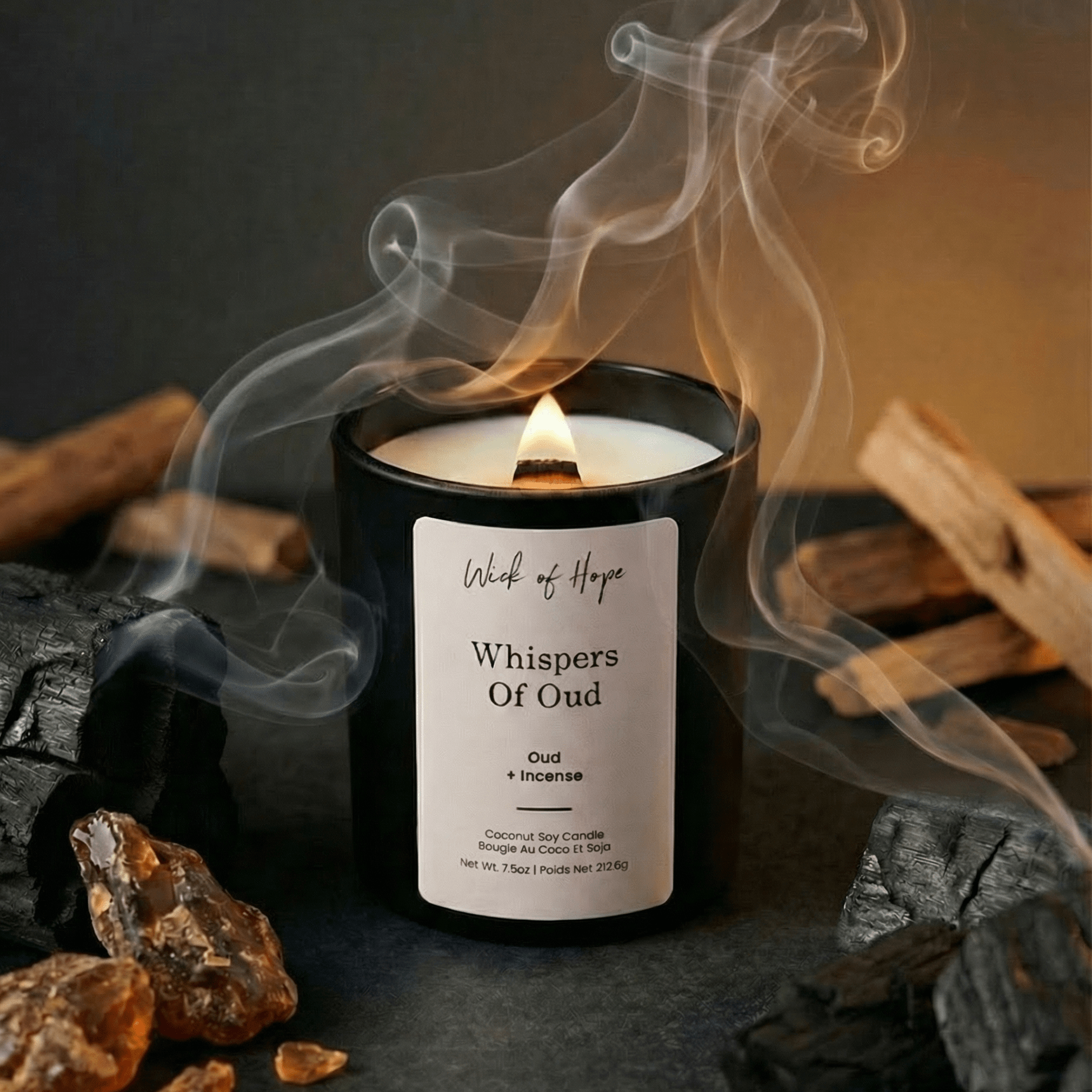 Candle labeled 'Whispers of Oud' with smoke and wooden elements on a dark background